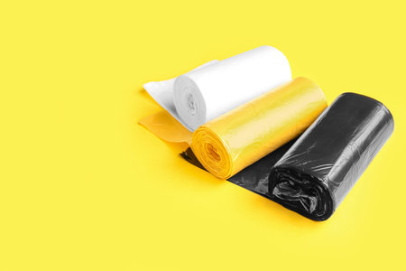 Different rolls of garbage bags on yellow backgroundの写真素材