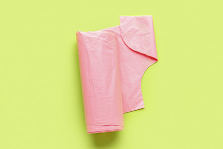 Pink roll of garbage bags on green backgroundの写真素材