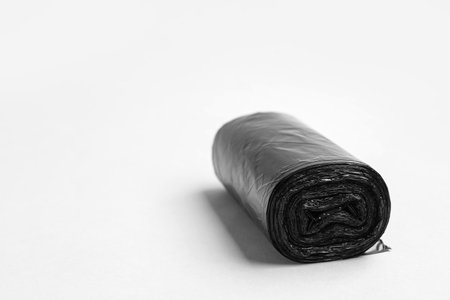 Black roll of garbage bags on gray backgroundの写真素材