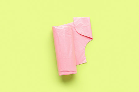 Pink roll of garbage bags on green backgroundの写真素材