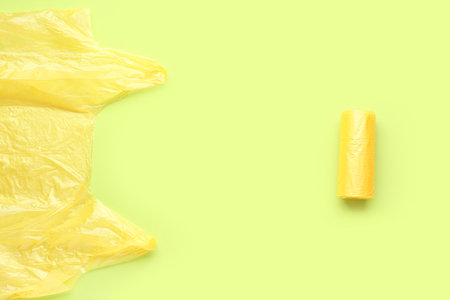 Rolled and unfolded garbage bags on green backgroundの写真素材