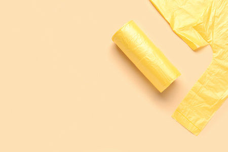 Rolled and unfolded garbage bags on beige backgroundの写真素材