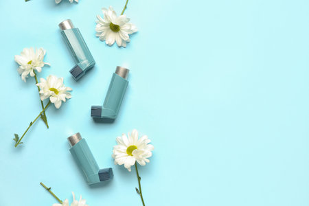 Asthma inhalers with daisy flowers on blue backgroundの写真素材