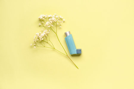 Asthma inhaler with flowers on green backgroundの写真素材