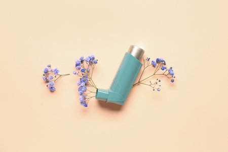 Asthma inhaler with gypsophila flowers on beige backgroundの写真素材