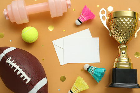 Blank card with gold cup, sports equipment and confetti on orange backgroundの写真素材