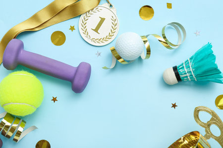 Frame made of sports equipment, first place medal and confetti on blue backgroundの写真素材