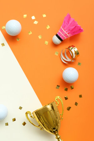 Frame made of gold cup, balls and confetti on color backgroundの写真素材