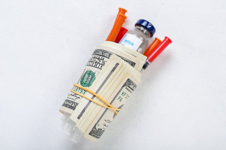 Insulin with syringes and money on white background. Expensive medicine conceptの写真素材