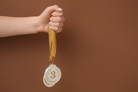 Woman with prize medals on brown backgroundの写真素材
