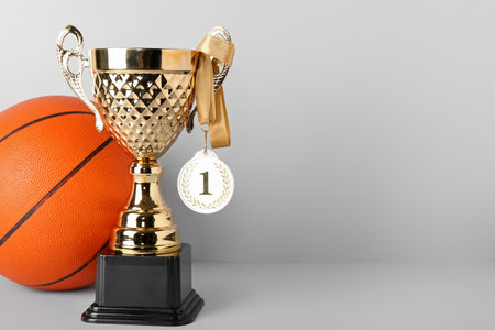 Gold cup with first place medal and ball on light backgroundの写真素材