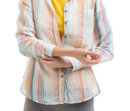 Young woman rolling up her sleeve on white backgroundの写真素材