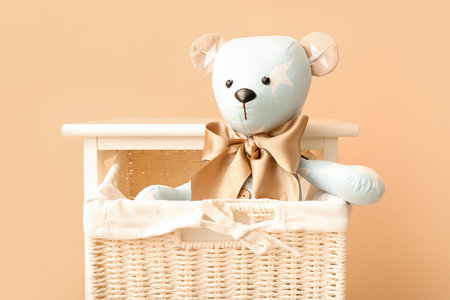 Toy bear in basket near beige wallの写真素材