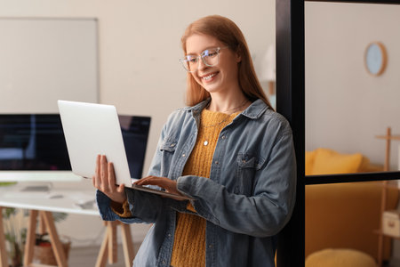Female programmer working with laptop in officeの写真素材