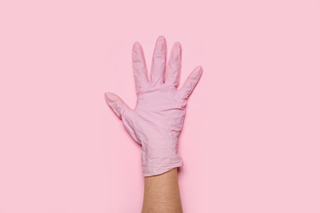 Woman in medical glove on pink backgroundの写真素材