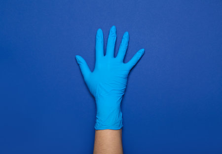 Woman in medical glove on blue backgroundの写真素材