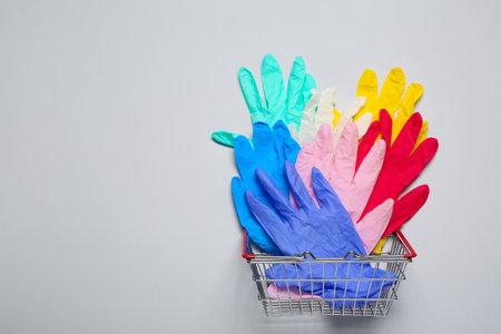 Shopping basket with medical gloves on gray backgroundの写真素材