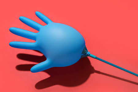 Inflated medical glove on red backgroundの写真素材