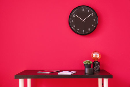 Workplace with tablet computer, notebook and cup near red wallの写真素材