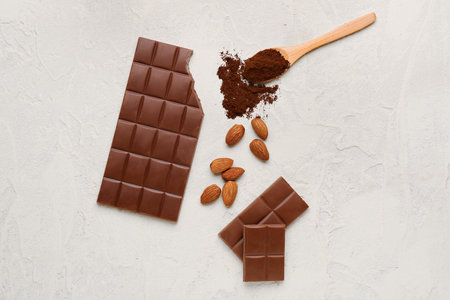 Composition with tasty chocolate, almond nuts and coffee powder on light backgroundの写真素材