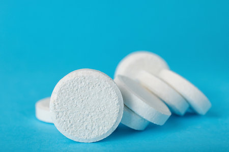 White soluble tablets on blue backgroundの写真素材