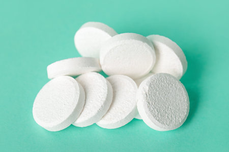 White soluble tablets on turquoise background
