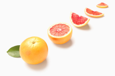 Composition with whole and cut grapefruits on white backgroundの写真素材