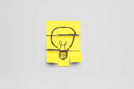 Sticky papers with drawn light bulb on light background. insight concept