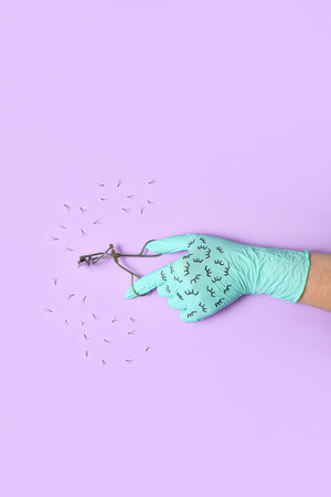 Beautician in rubber glove with curler and fake eyelashes on lilac background