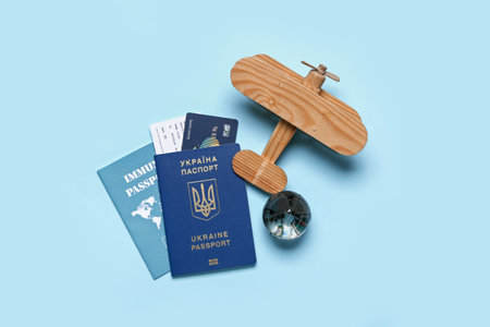 Ukrainian and immune passports with wooden airplane on blue backgroundの写真素材