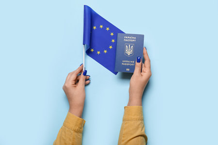 Woman with Ukrainian passport and flag of European Union on blue backgroundの写真素材