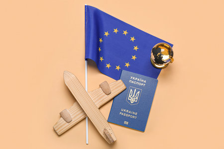 Ukrainian passport with wooden airplane and flag of European Union on beige backgroundの写真素材