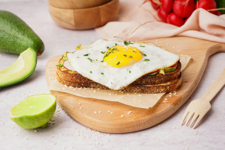 Delicious sandwich with fried egg on light backgroundの写真素材