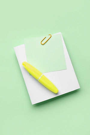 Sticky notes with paper clip and marker on green backgroundの写真素材