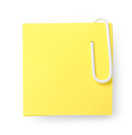 Yellow sticky note with paper clip on white backgroundの写真素材