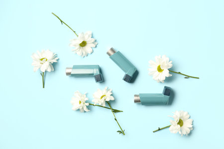 Asthma inhalers with daisy flowers on blue backgroundの写真素材