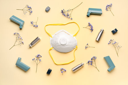 Asthma inhalers with mask and flowers on yellow backgroundの写真素材