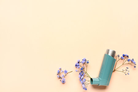 Asthma inhaler with gypsophila flowers on beige backgroundの写真素材