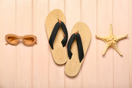 Flip-flops with sunglasses and starfish on beige wooden backgroundの写真素材