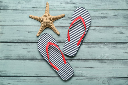 Flip-flops with starfish on blue wooden backgroundの写真素材