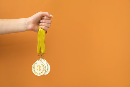 Woman with prize medals on orange backgroundの写真素材