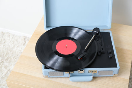 Record player with vinyl disk on table near light wall in room, closeupの写真素材