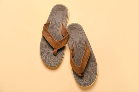 Brown flip-flops on beige backgroundの写真素材