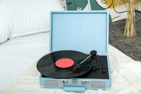 Record player with vinyl disk on blanket in bedroomの写真素材
