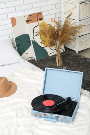 Record player with vinyl disk on bed in roomの写真素材
