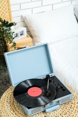 Record player with vinyl disk on pouf in bedroomの写真素材
