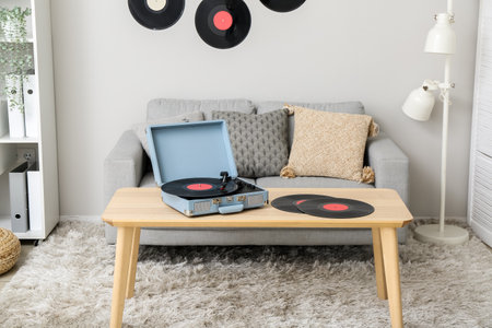 Record player with vinyl discs on table in interior of living roomの写真素材