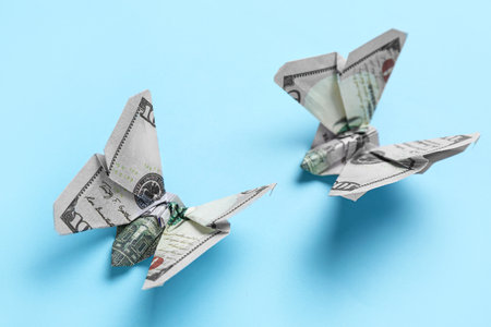 Origami butterflies made of dollar banknotes on blue background, closeupの写真素材