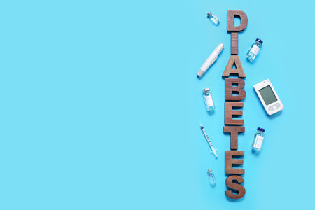 Word DIABETES with insulin, lancet pen and glucometer on blue backgroundの写真素材