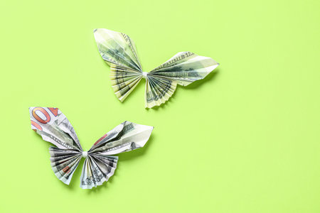 Origami butterflies made of dollar banknotes on green backgroundの写真素材
